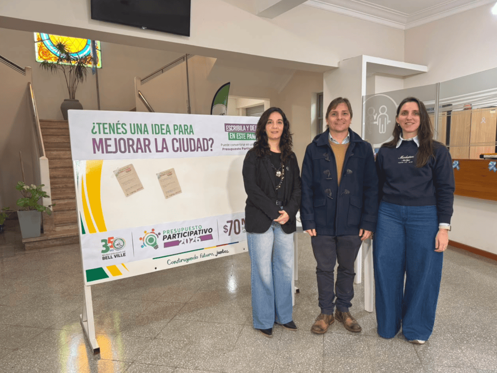 Juan Manuel Moroni y funcionarias municipales presentan la tercera edición del Presupuesto Participativo junto a funcionarias municipales en el hall del Palacio Municipal de Bell Ville.