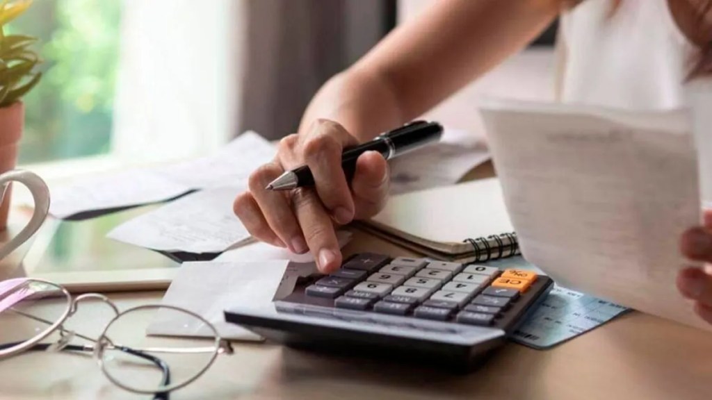 Persona revisa documentación y realiza cálculos con una calculadora, imagen ilustrativa del programa Alivio Fiscal 2026.